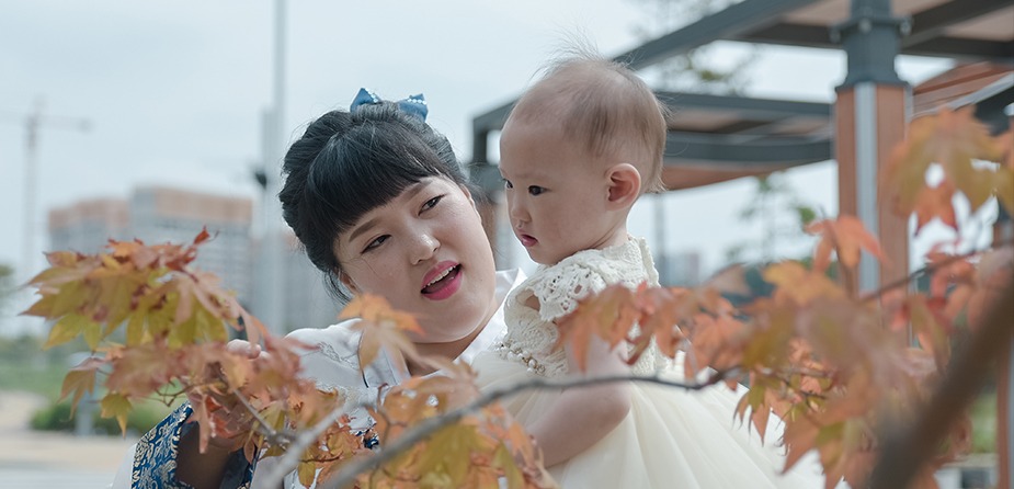 엄마가 예빈이를 안고 단풍나무 가지 사이에서 — 엄마가 잎을 만지며 예빈이를 바라보는 컷